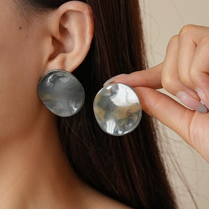 Gros plan sur les boucles d'oreilles rondes en acrylique écaille gris aurore et argent