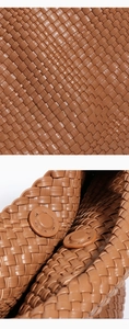 Detail of caramel brown hand-woven leather bag with magnetic buckle closure system