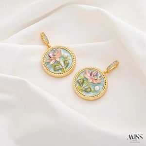 Macro shot of vintage lotus pendants with blue enamel and pearls on white silk