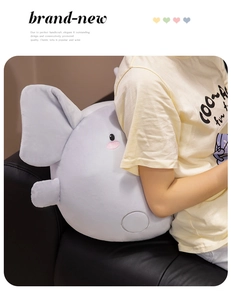 Macro detail of plush elephant cushion showing soft fabric and embroidered facial features