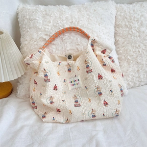 Close-up of quilted canvas tote bag with rabbit circus print and woven handles