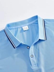 Vue rapprochée du col polo bleu clair avec étiquette de taille M et 100% polyester