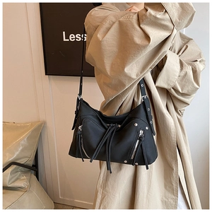 Dettaglio borsa biker nera con rivetti argentati e cerniere con lunghe nappe in pelle