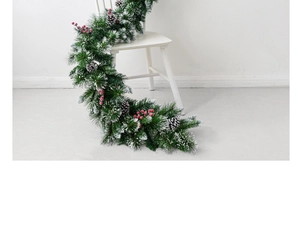 Detail of luxury PE mixed Christmas garland with red berries and snow-dusted pine cones