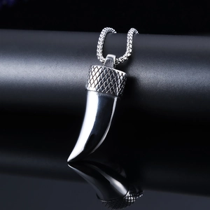 Polished silver stainless steel wolf tooth pendant necklace on a sleek black display stand