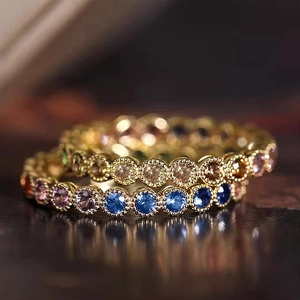 Detailed close-up of eternity band ring with colorful zircons and golden finish
