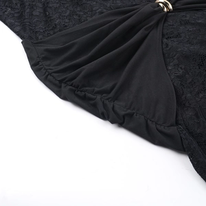 Detailed close-up of black lace fabric with pleated knit and gold ring accent