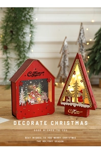 Close-up of lighted red wooden Christmas house ornament with festive LED glow