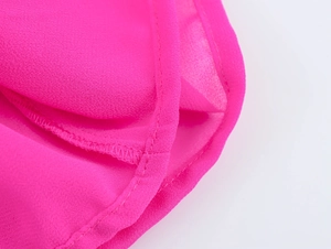 Gros plan sur la texture du tissu mousseline rose et les coutures du haut