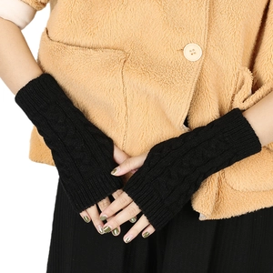 Close-up of black cable knit fingerless gloves with soft wool blend texture
