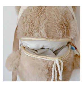 Detailed close-up of brown plush bear backpack with zipper opening and soft fur texture