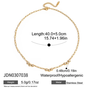 Detail of stainless steel necklace with sparkling cubic zirconia charms and gold plating