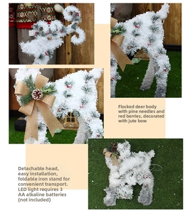 Detail of white flocked Christmas reindeer featuring pine needles, red berries and LED lights