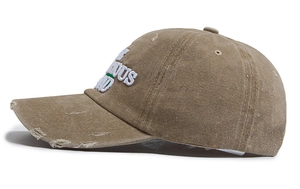 Detail of washed khaki baseball cap featuring vintage distressed edges and side embroidery