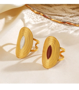 Detail of vintage gold oval rings with white and dark red enamel on silk background