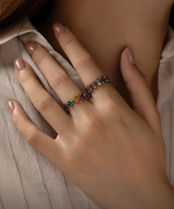 Close-up of black plated S925 silver rings with colorful floral and oval gemstones