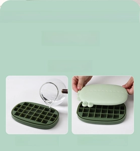 Detail of green silicone ice cube tray with cute dinosaur embossed lid and base