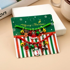 Close-up of Christmas charm bracelet with enamel reindeer and bells on festive card