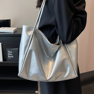 Grand sac cabas argenté avec texture plissée et finition brillante porté à l'épaule