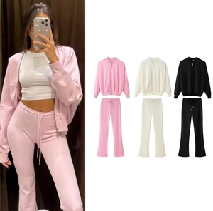 Close-up of women's zip-up bomber jacket and flared pants set in pink, white, and black
