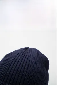 Close-up of navy ribbed knit beanie texture showing warm thick yarn and windproof weave
