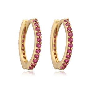 Detail of gold hoop earrings with pavé-set red round cubic zirconia on white background