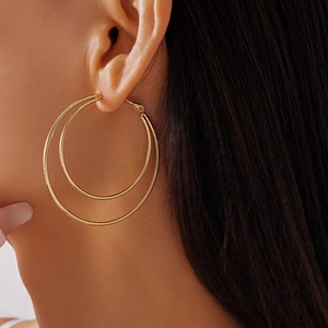 Close-up of elegant double-layered gold geometric hoop earrings worn by a model