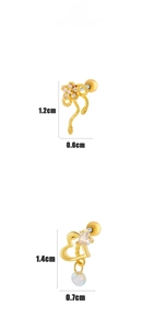 Detailed view of heart-shaped gold studs with zircon and decorative beads for cartilage
