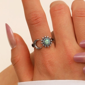Close-up of vintage sun and moon ring with iridescent opal stone on model hand
