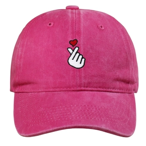 Detail of heart gesture embroidery on bright pink washed cotton baseball cap texture