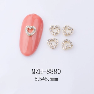 Detailed view of gold alloy heart nail charms with 5.5mm size and rhinestone inlay