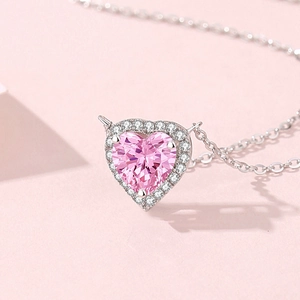 S925 silver heart necklace with pink stone and small diamonds on a soft pink background