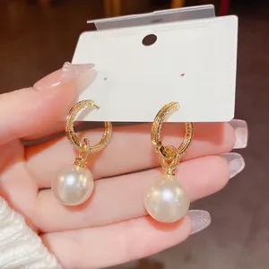 Exquisite 14K gold pearl earrings featuring pavé cubic zirconia hoops and round white pearls