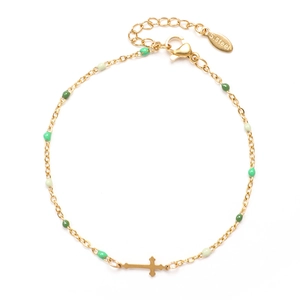 Detail of gold stainless steel bracelet with green enamel beads and cross charm