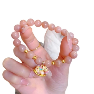Pink sunstone beaded bracelet with golden rocking horse charm and colorful enamel details