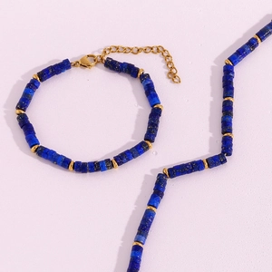 Detail of beaded jewelry set with lapis blue cylindrical stones and gold metal spacers