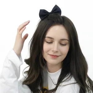 Eleganter schwarzer Satin-Schleifen-Haarclip für Damen, getragen von einem Modell