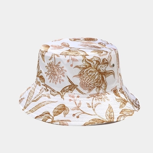 Dettaglio cappello pescatore pieghevole bianco con motivi floreali marroni e occhielli