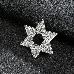 Detailed macro view of Star of David brooch with shimmering crystals on black leather