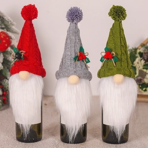 Tre copribottiglie di vino gnomo natalizio in maglia nei colori rosso, grigio e verde