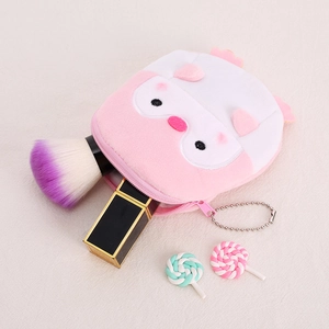 Cute pink owl plush coin purse with makeup brushes on minimalist cream background