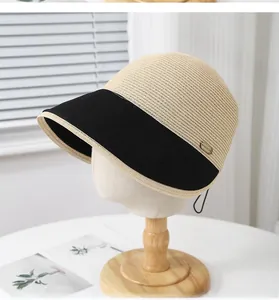 Detail of two-tone straw equestrian hat with FASHION metal tag and black fabric brim