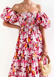 Detail of off-shoulder floral dress featuring elastic shirred bodice and tiered ruffle hem