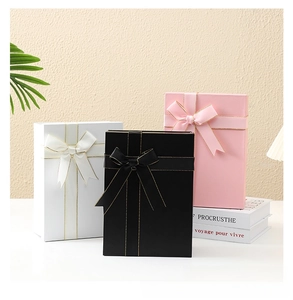 Close-up of premium collapsible gift boxes with silk ribbon bows in black white and pink