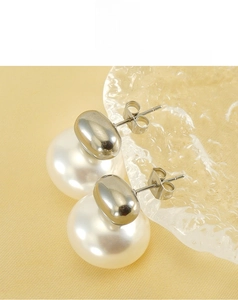 Macro shot of vintage pearl earrings featuring 18K gold finish on titanium steel studs