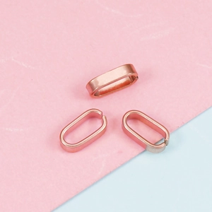 Macro detail of three rose gold stainless steel oval pinch bails for jewelry making
