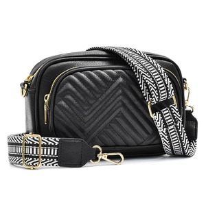 Detail of black quilted leather bag featuring a patterned wide strap and gold hardware