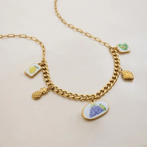 Détail du collier en acier titane doré avec breloques de fruits colorés comme l'ananas