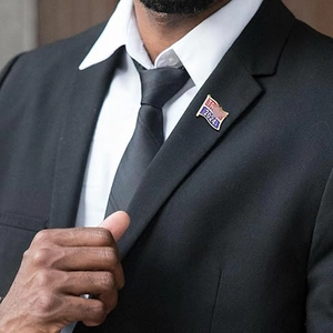 Professional metal American flag brooch with Trump 2024 text worn on a suit jacket lapel
