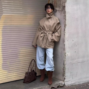 Women's khaki trench coat with wide shoulders, stand collar and waist belt in urban style